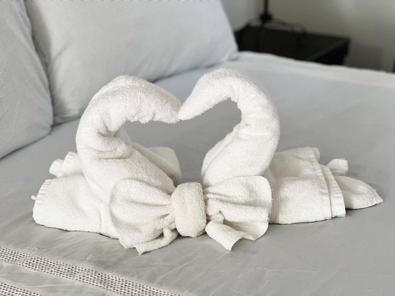 Freshly made bed with hand-folded towel swans